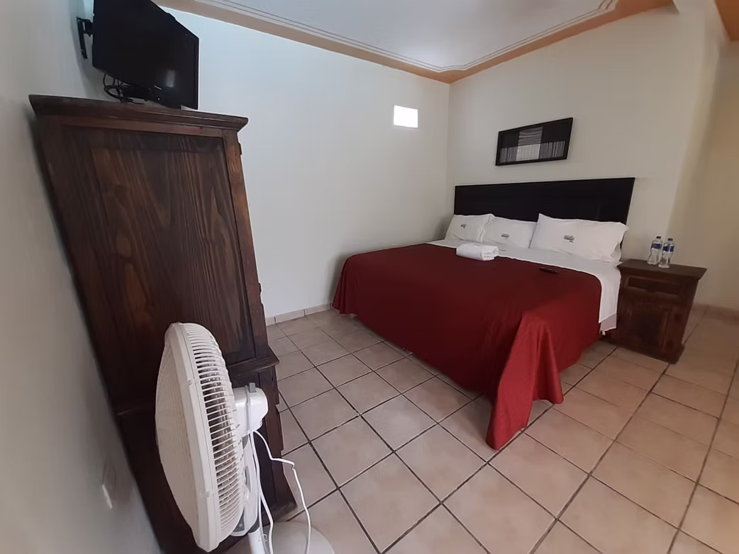 Habitación con cama matrimonial y televisión